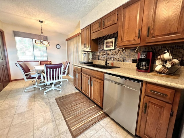 kitchen with brown cabinets, light countertops, a sink, and stainless steel dishwasher