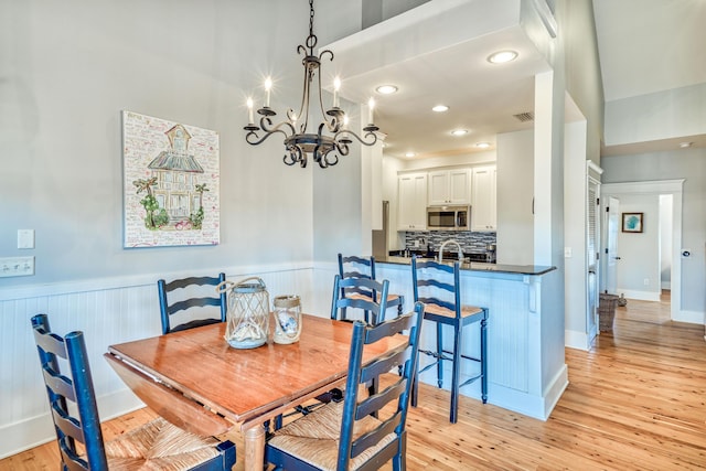 dining space with a chandelier and light hardwood / wood-style flooring