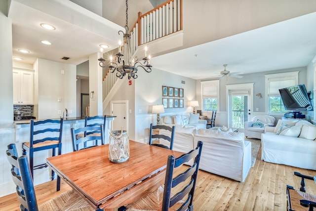 dining area featuring ceiling fan with notable chandelier and light wood-type flooring