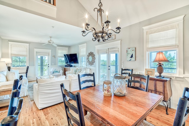 dining room with high vaulted ceiling, light hardwood / wood-style floors, french doors, and a healthy amount of sunlight