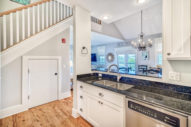 kitchen featuring sink, dishwasher, white cabinetry, decorative light fixtures, and dark stone counters