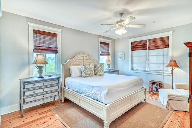 bedroom with multiple windows, ceiling fan, and light wood-type flooring