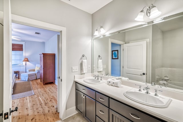 bathroom featuring wood-type flooring, a bathtub, and vanity