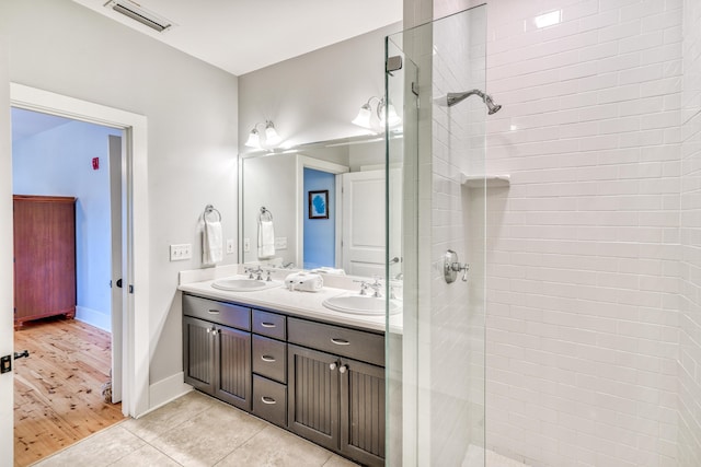 bathroom featuring vanity, tile patterned flooring, and a tile shower