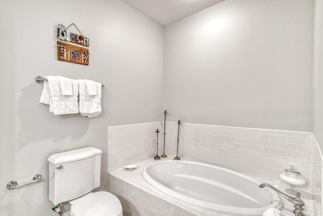 bathroom with tiled tub and toilet