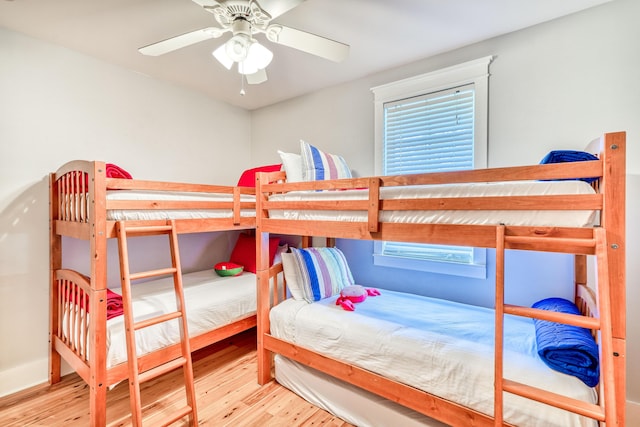 bedroom featuring ceiling fan, multiple windows, and light hardwood / wood-style flooring