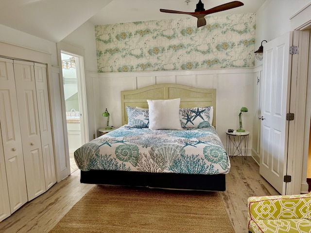 bedroom with hardwood / wood-style floors, a closet, ceiling fan, and ensuite bathroom