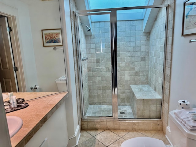 bathroom with vanity, a skylight, and a shower with door