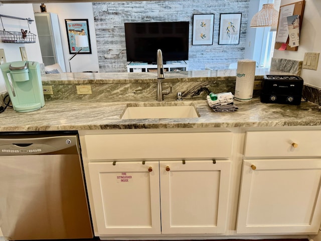 kitchen with white cabinetry, dishwasher, sink, and light stone counters