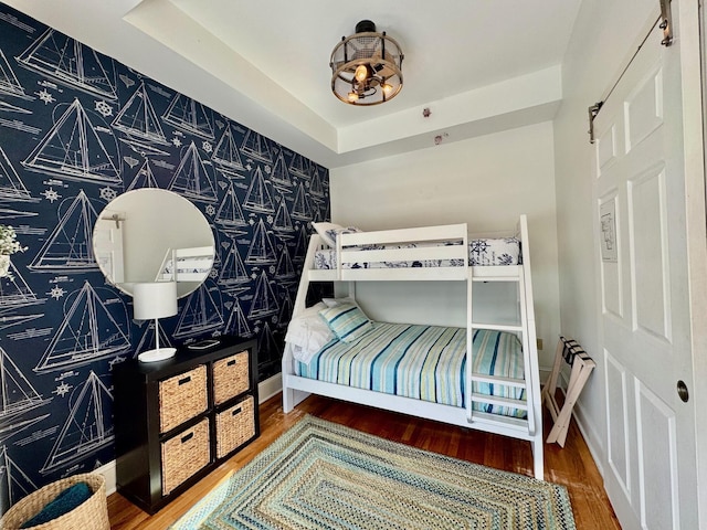 bedroom featuring a tray ceiling and wood-type flooring