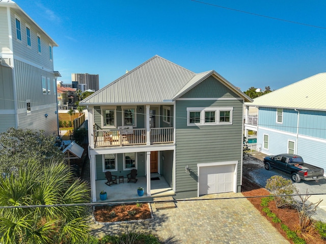 view of front of house featuring a balcony, a garage, and covered porch