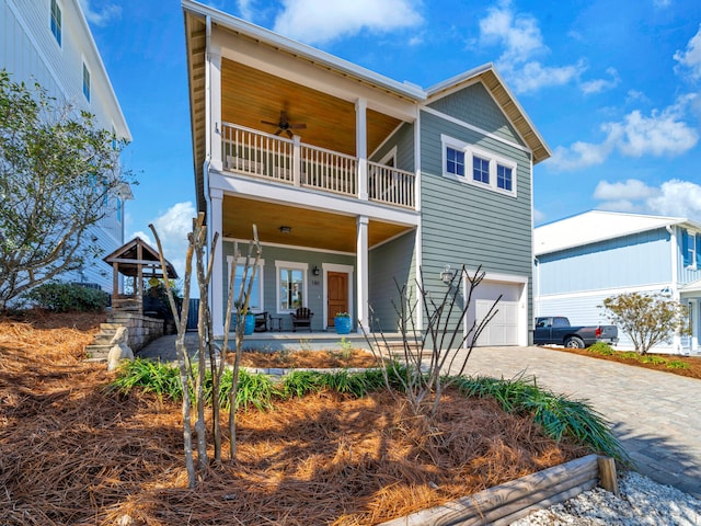 view of front of house with a garage, ceiling fan, a balcony, and covered porch