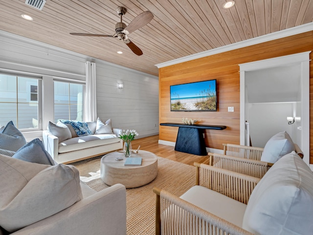 living room with crown molding, wood-type flooring, wooden ceiling, and wooden walls