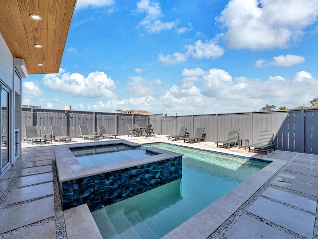 view of swimming pool with an in ground hot tub and a patio area