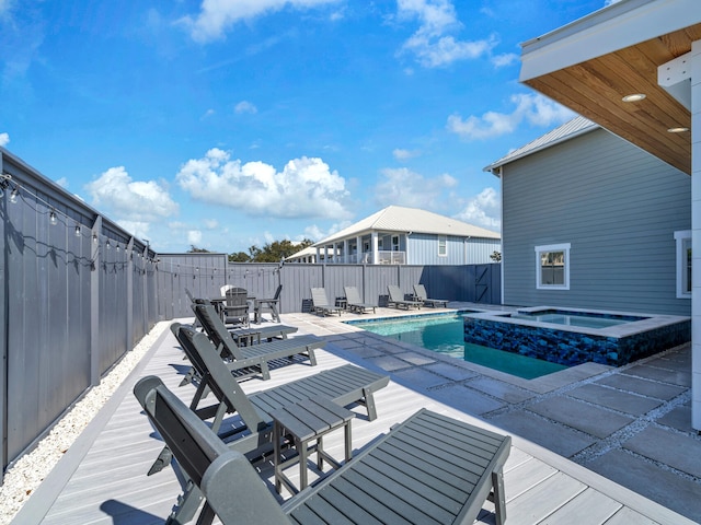 view of swimming pool featuring a patio area and an in ground hot tub