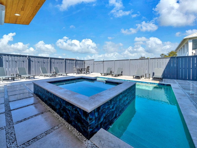 view of swimming pool with an in ground hot tub and a patio