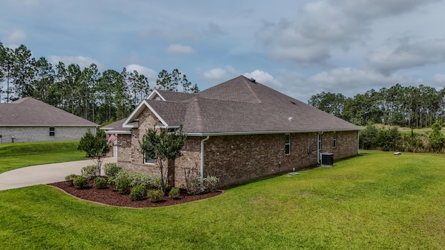 132 Gulf Pines Ct, Freeport, FL 32439 - view of home's exterior featuring a yard, concrete driveway, a shingled roof, brick siding, and central AC unit