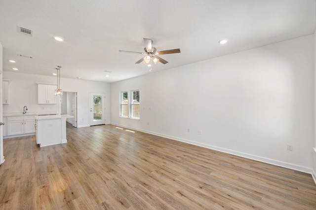 unfurnished living room with light hardwood / wood-style flooring and ceiling fan