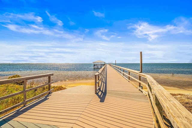 view of dock featuring a view of the beach and a water view