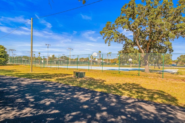 view of property's community featuring basketball court and a lawn