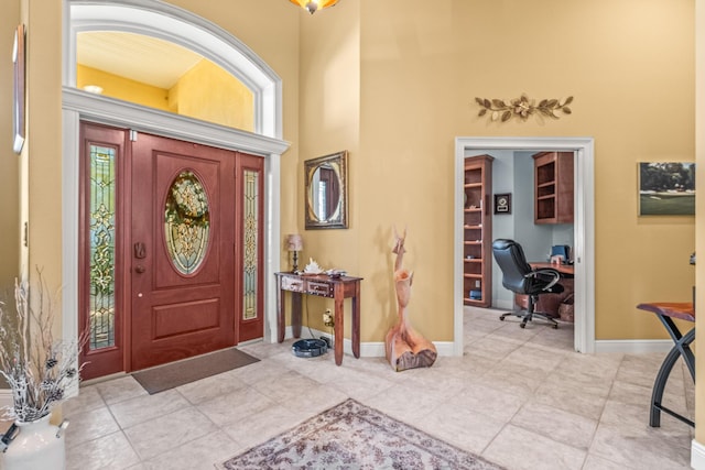 foyer featuring light tile patterned flooring and a high ceiling