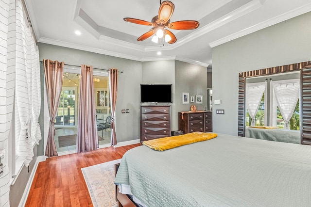 bedroom featuring crown molding, a raised ceiling, hardwood / wood-style flooring, ceiling fan, and access to exterior