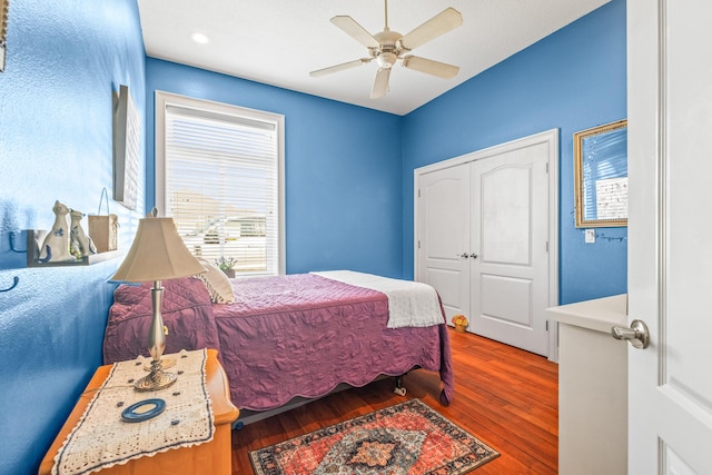 bedroom with hardwood / wood-style flooring, a closet, and ceiling fan