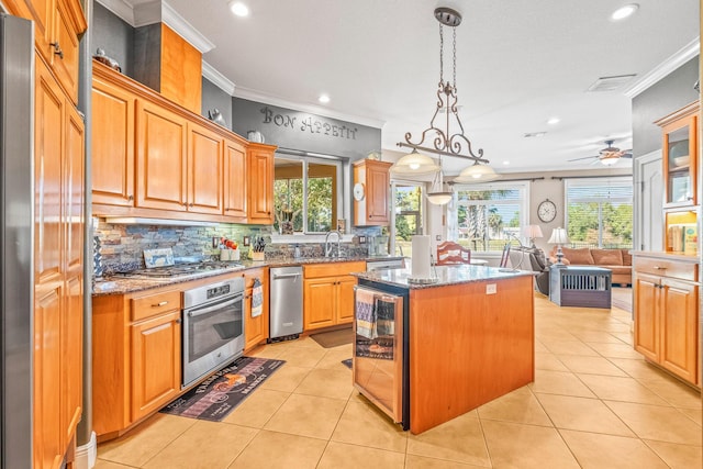 kitchen featuring wine cooler, hanging light fixtures, light tile patterned floors, appliances with stainless steel finishes, and a kitchen island