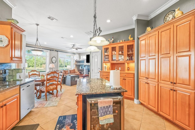 kitchen featuring hanging light fixtures, a kitchen island, stainless steel dishwasher, beverage cooler, and dark stone counters