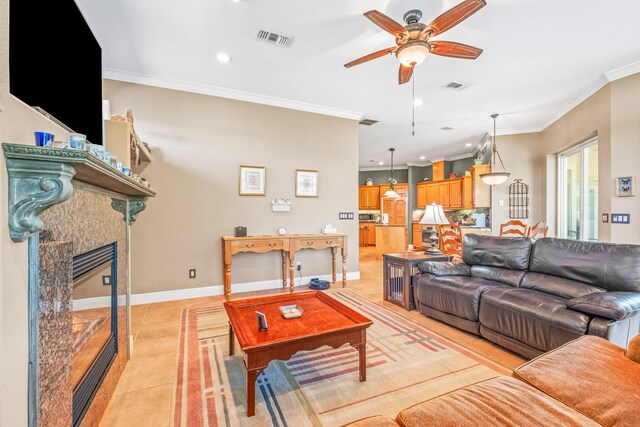 living room featuring crown molding, light tile patterned floors, and ceiling fan