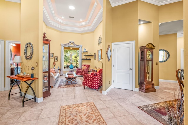 foyer entrance featuring light tile patterned floors, ornamental molding, and a high ceiling