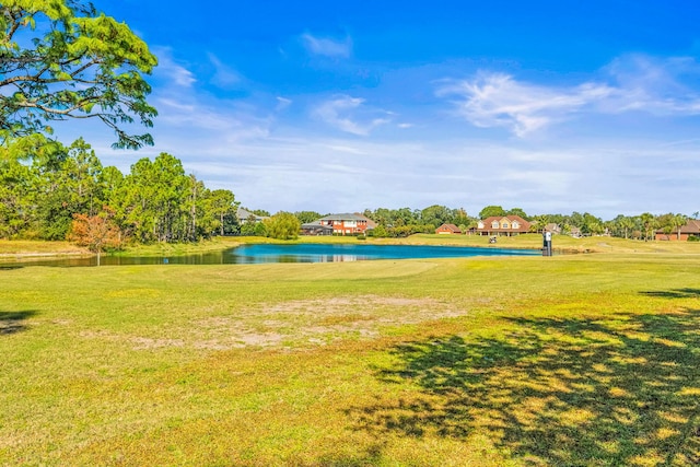 surrounding community with a water view and a lawn