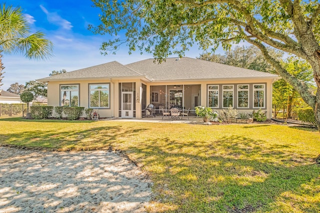 rear view of house featuring a yard, a patio area, and a sunroom