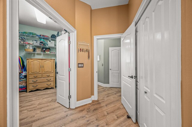 hallway with baseboards and light wood finished floors