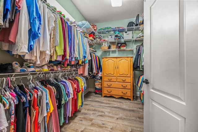 walk in closet with wood finished floors