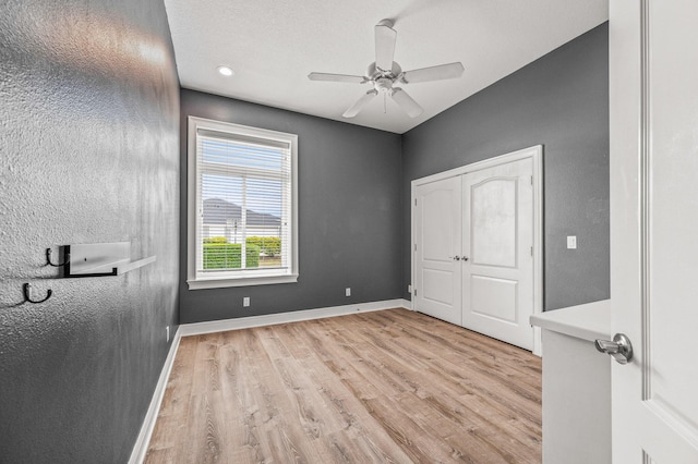 unfurnished bedroom featuring baseboards, a ceiling fan, and light wood finished floors