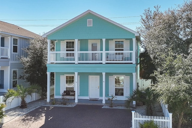 view of front of home featuring a balcony, fence, and a porch