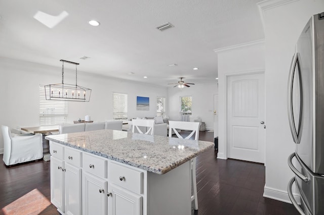 kitchen featuring visible vents, open floor plan, dark wood finished floors, and freestanding refrigerator