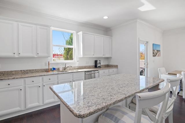 kitchen with crown molding, dark wood-type flooring, white cabinets, a sink, and dishwasher