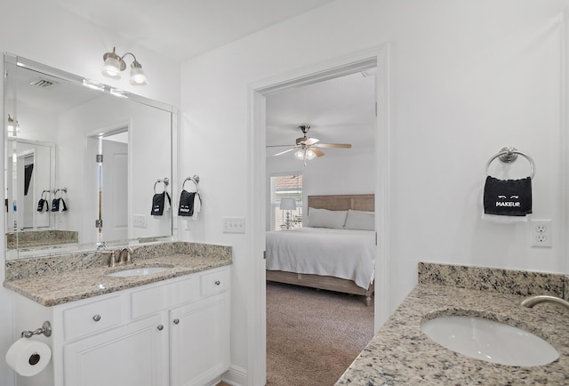 full bathroom with ceiling fan, two vanities, a sink, and ensuite bathroom