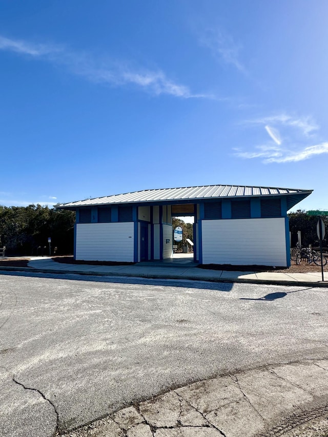 view of front of house with a standing seam roof, metal roof, and a carport