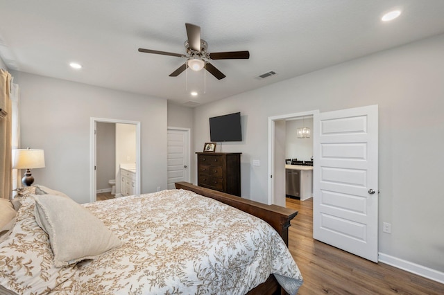 bedroom featuring connected bathroom, hardwood / wood-style floors, and ceiling fan