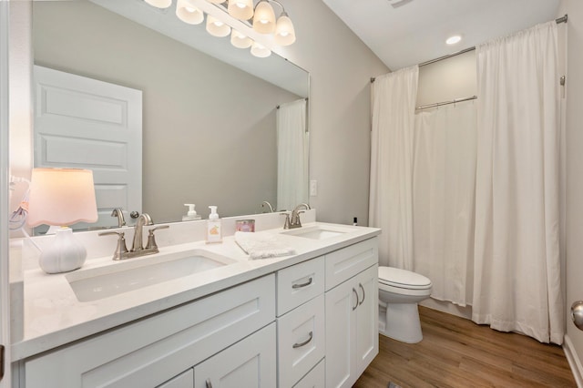 bathroom featuring wood-type flooring, toilet, and vanity