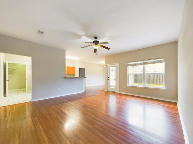 unfurnished living room featuring ceiling fan and wood-type flooring