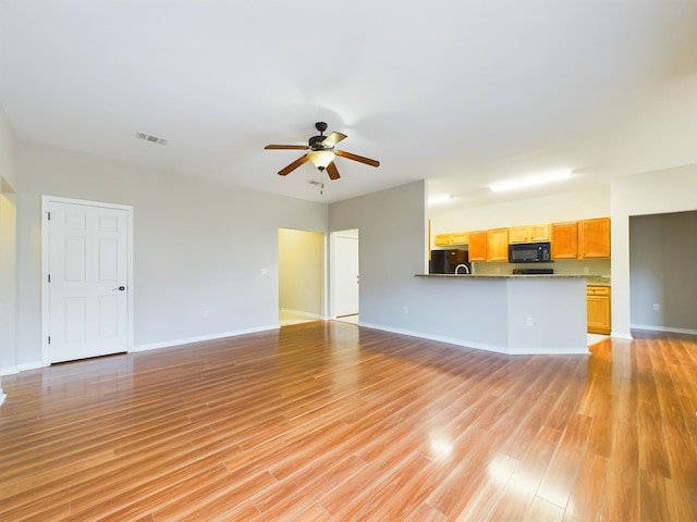 unfurnished living room featuring ceiling fan and light hardwood / wood-style flooring