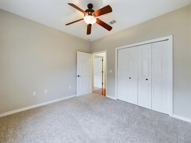 unfurnished bedroom with ceiling fan, carpet, and a closet