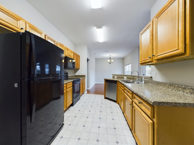 kitchen featuring hanging light fixtures, sink, black appliances, and a notable chandelier