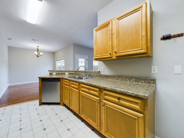 kitchen with hanging light fixtures, stainless steel dishwasher, sink, an inviting chandelier, and kitchen peninsula