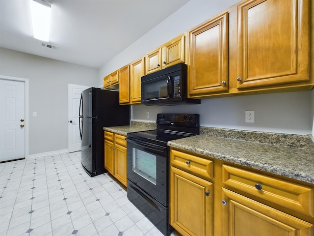 kitchen featuring dark stone counters and black appliances