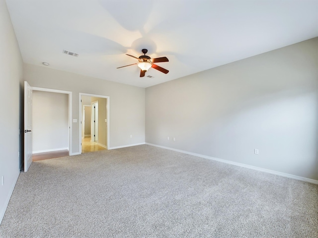 spare room featuring light carpet and ceiling fan